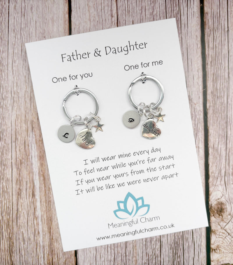 Two keychains on a card with a message for a father and daughter, on a wooden surface.