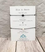 Pair of black bracelets with text on a white card against a wooden background