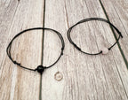Two black beaded bracelets on a wooden surface