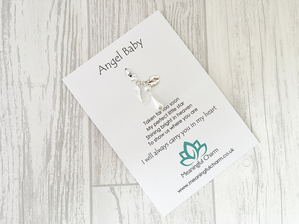 Angel Baby charm on a card with text and branding on a wooden surface
