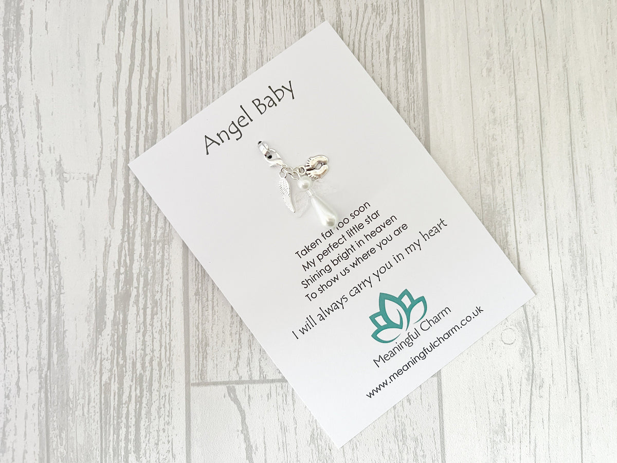 Angel Baby charm on a card with text and branding on a wooden surface